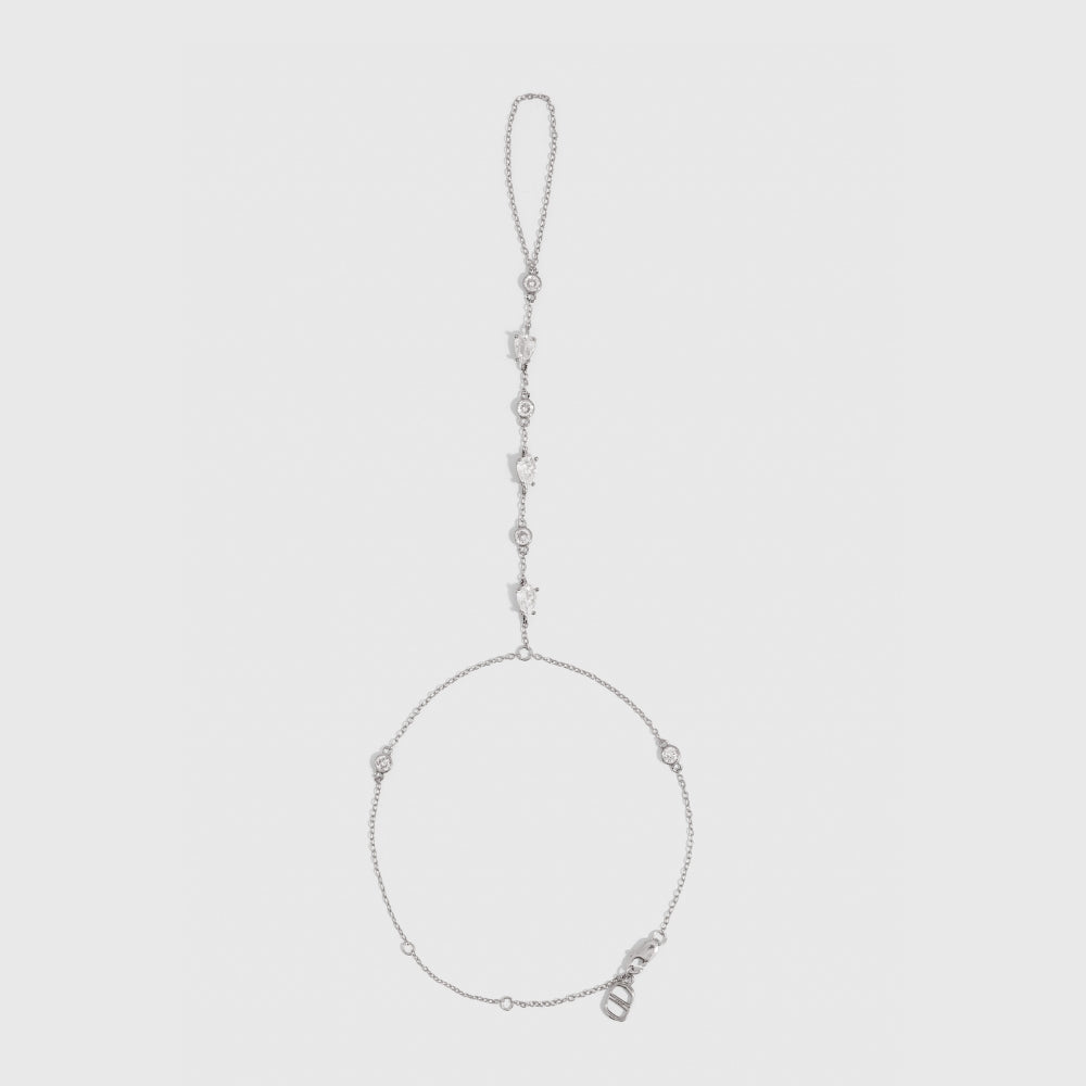 Silver hand chain bracelet with round-cut and teardrop-cut cubic zirconia detailing, shown on a plain background.