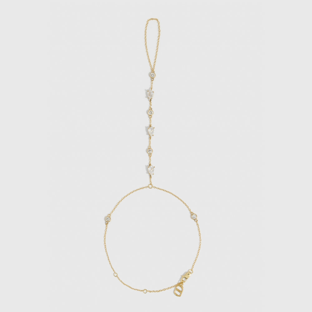 14k gold plated hand chain bracelet with round-cut and teardrop-cut cubic zirconia detailing, shown on a plain background.