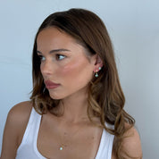 Woman wearing a white tank top with a plain background