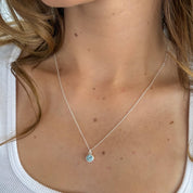 Necklace with a blue pendant worn by a person