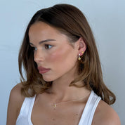 Woman wearing a white tank top against a light blue background