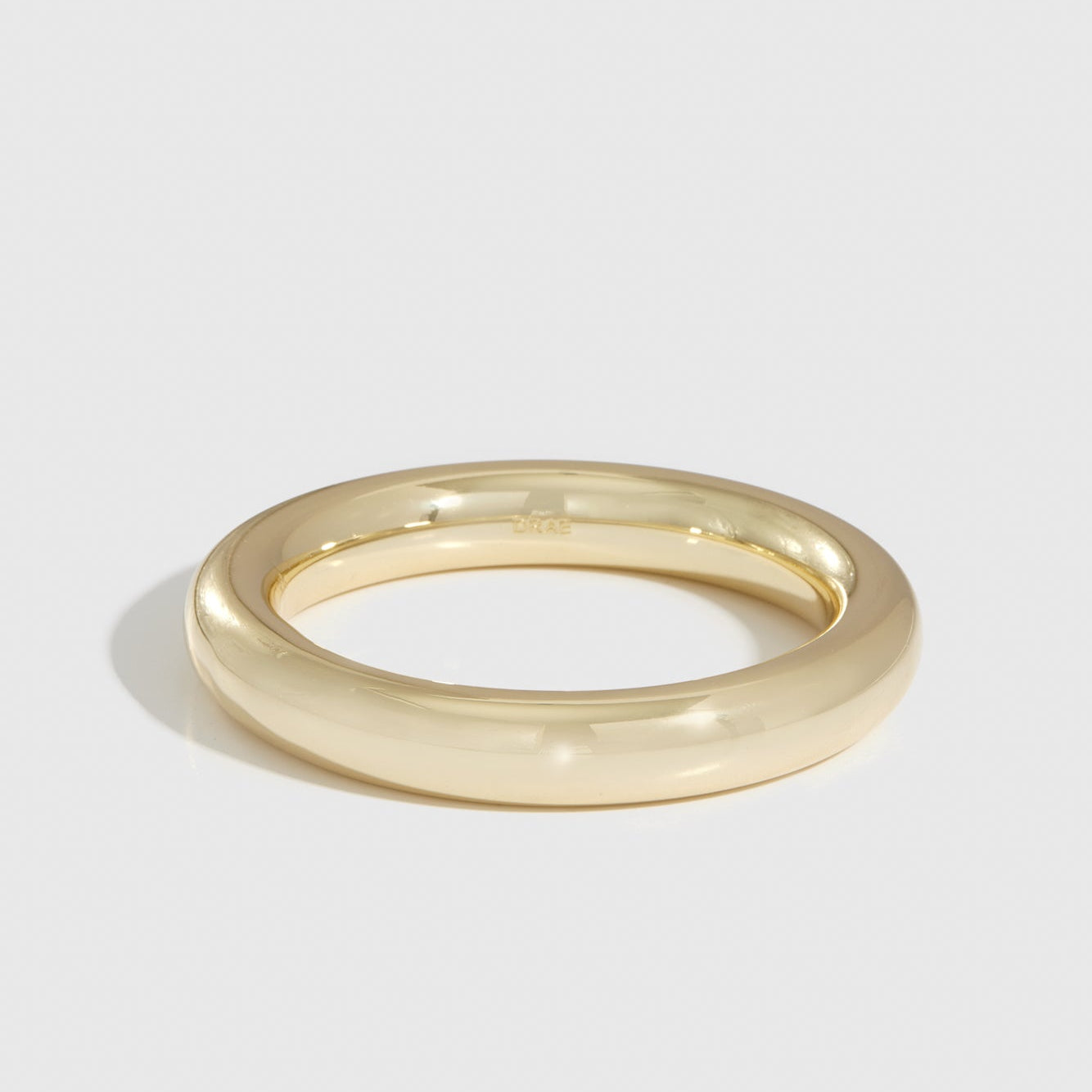 14k gold plated tube bangle, shown on a plain background.