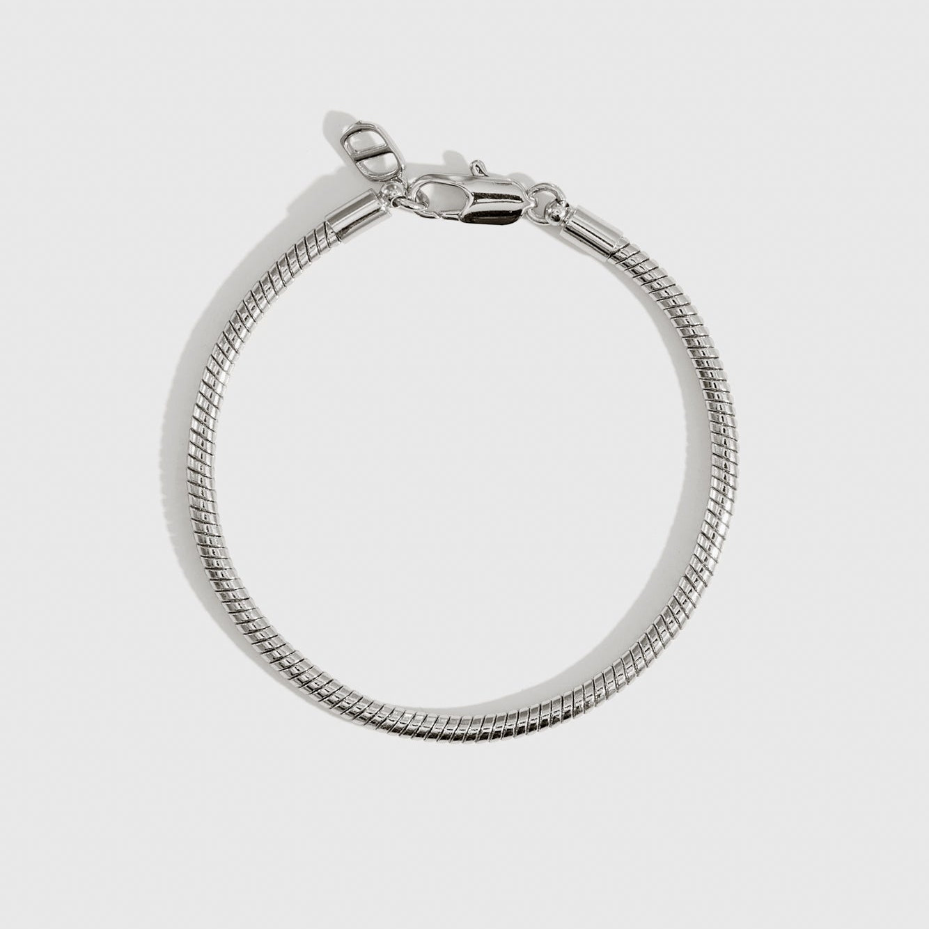 Silver plated round snake chain bracelet, shown on a plain background.