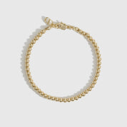 14k gold plated small beaded bracelet, shown on a plain background.