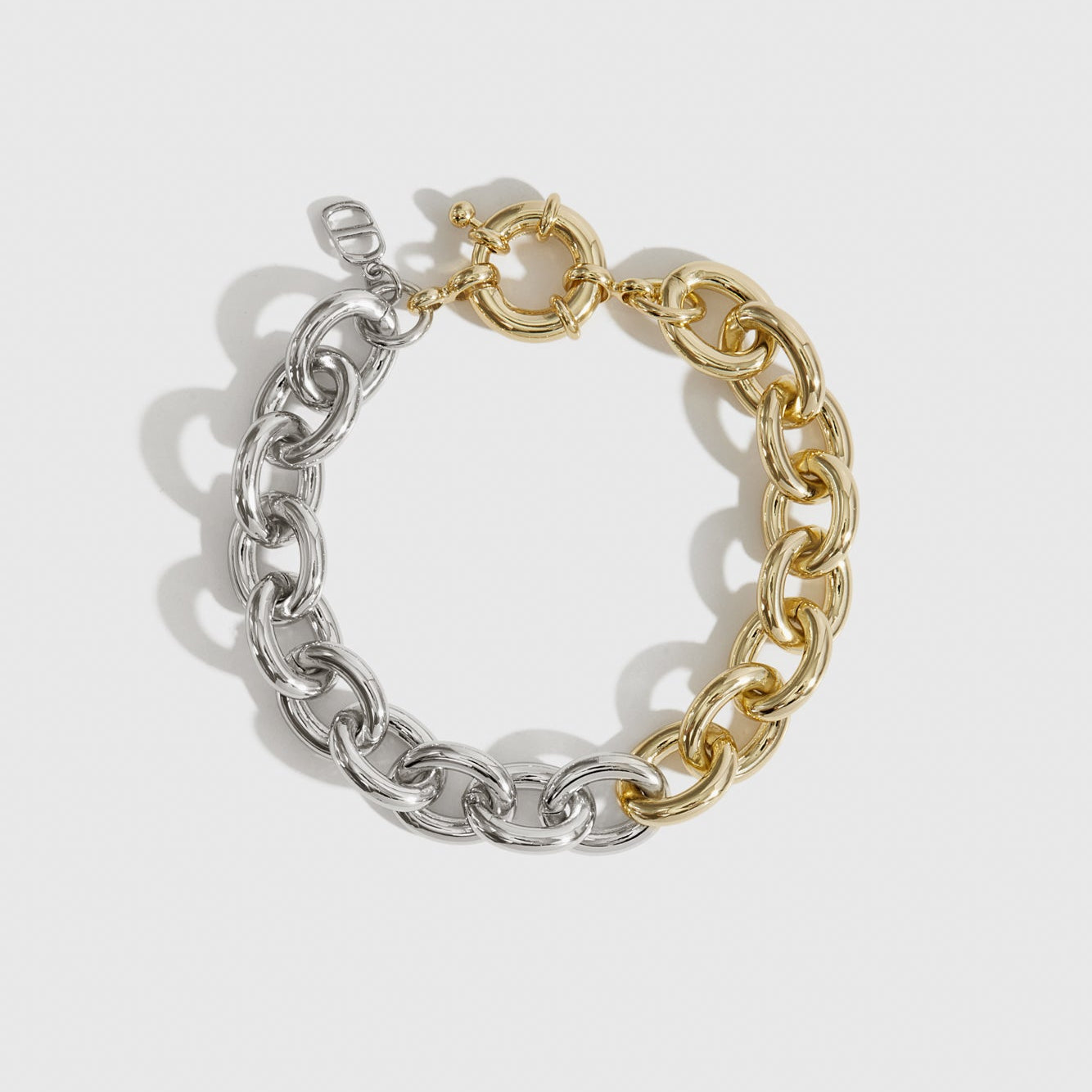 Mixed metal small oval link bracelet, shown on a plain background.