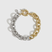 Mixed metal small oval link bracelet, shown on a plain background.