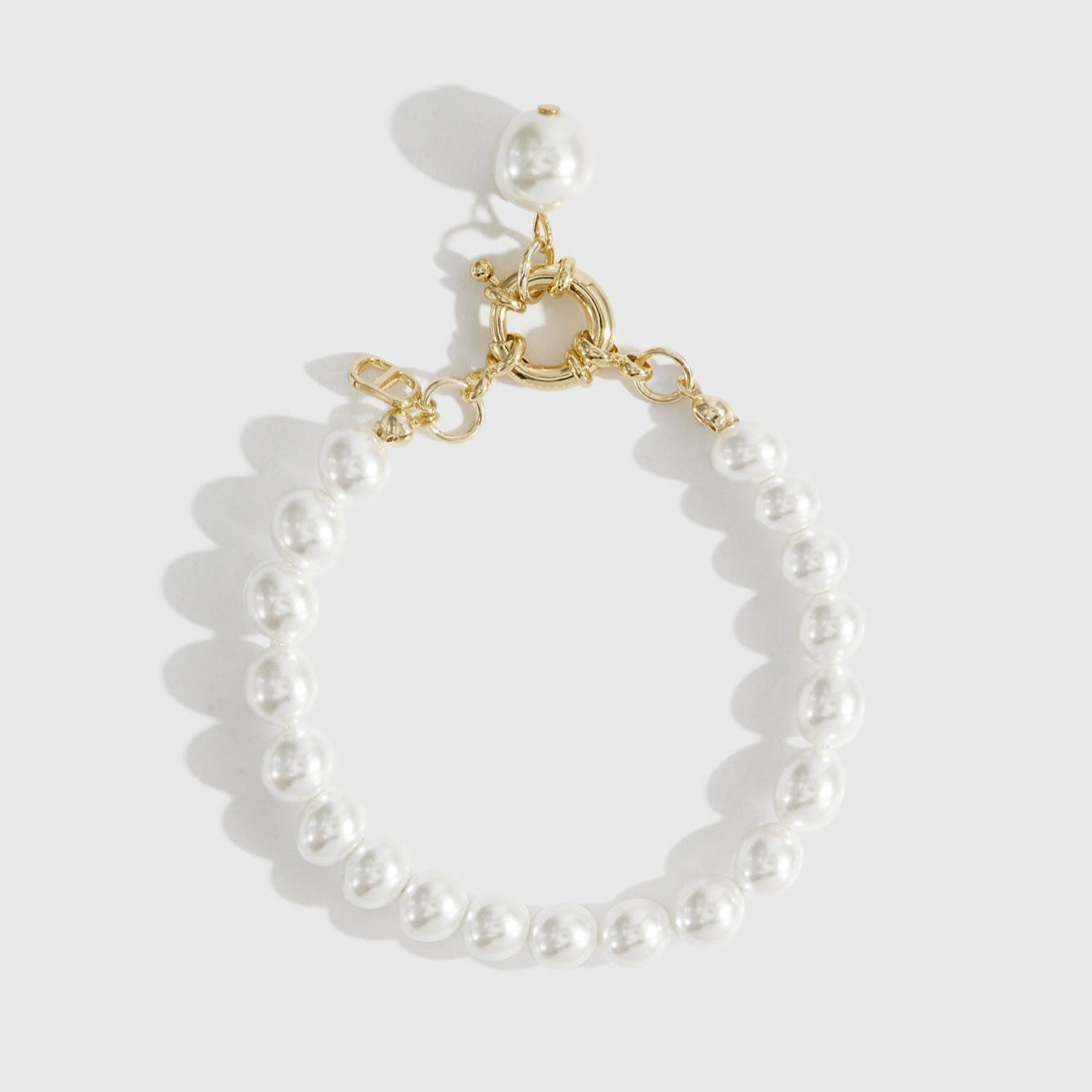 14k gold plated single row pearl bracelet with pearls, shown on a plain background.