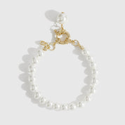 14k gold plated single row pearl bracelet with pearls, shown on a plain background.