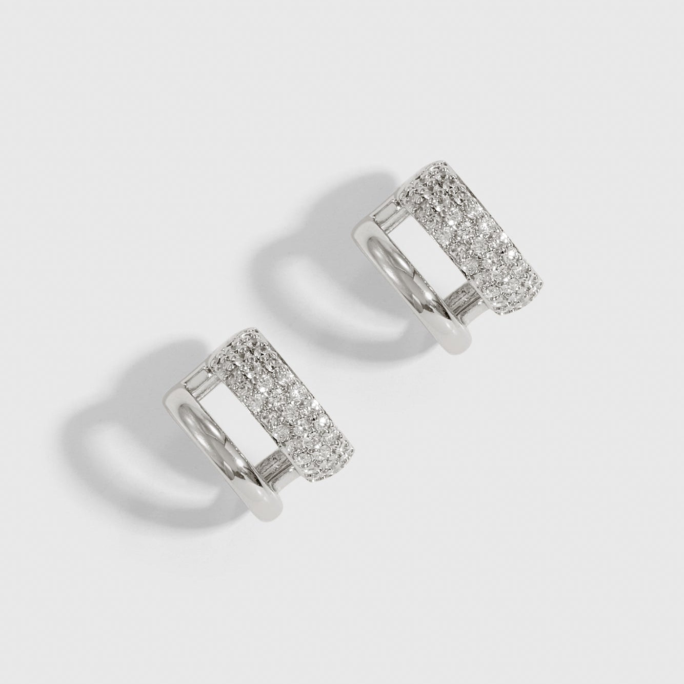 Silver plated double pavé hoop earrings with pavé cubic zirconia, shown on a plain background.