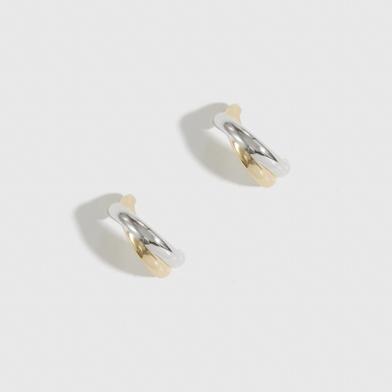 Mixed metal X's hoop earrings, shown on a plain background.