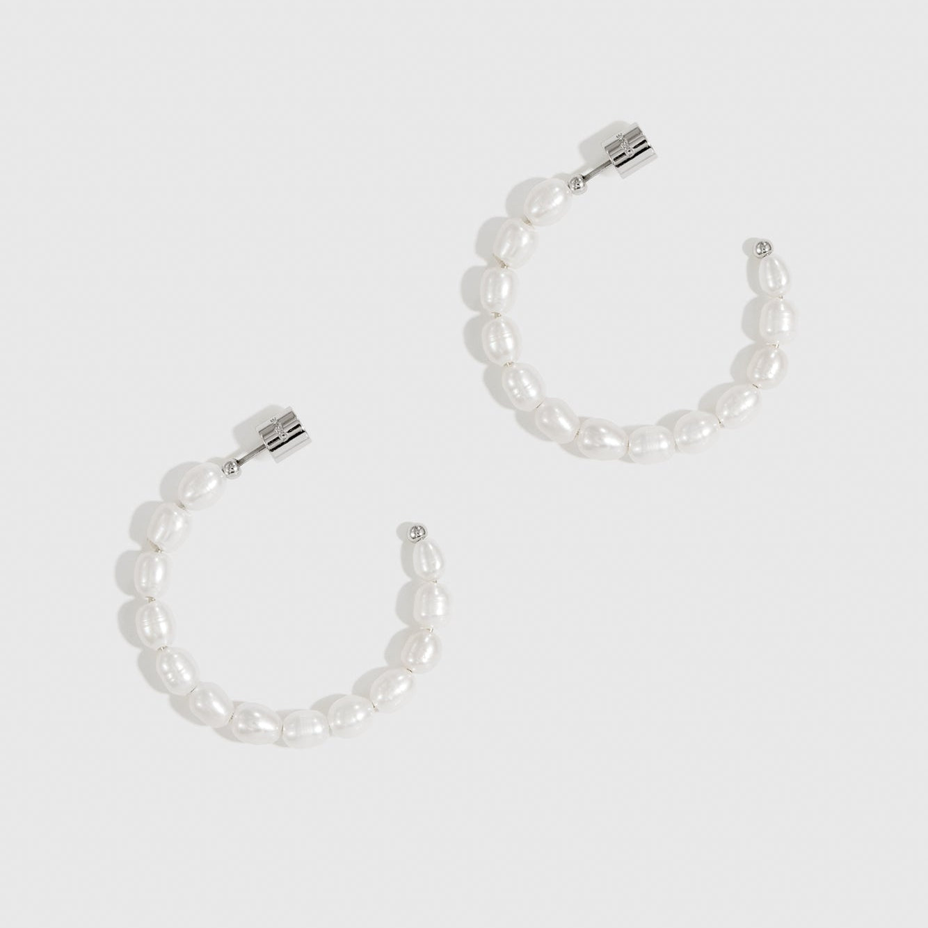 Silver plated freshwater pearl hoop earrings with freshwater pearls, shown on a plain background.