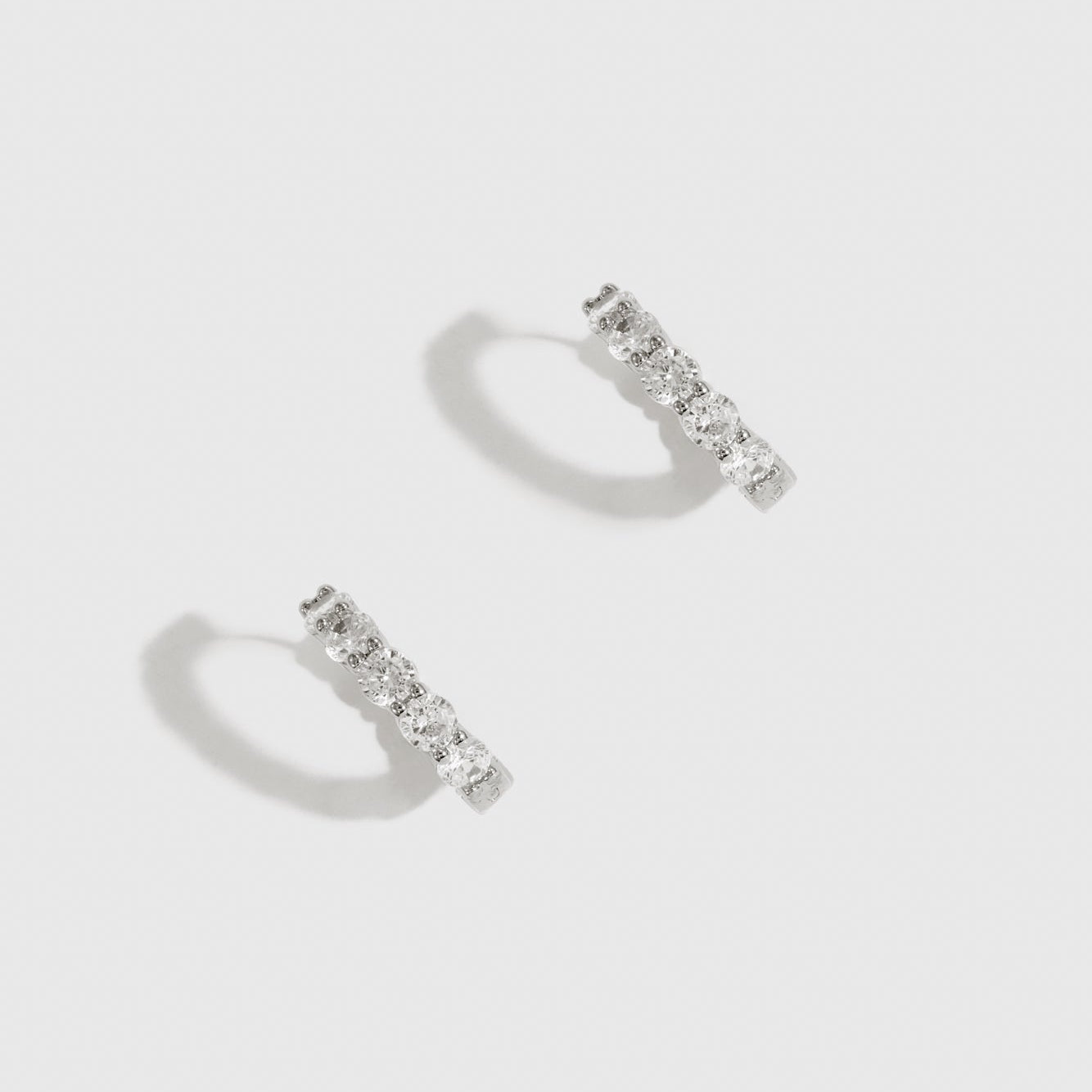 Sterling silver 925 inside-out pavé huggies with cubic zirconia, shown on a plain background.