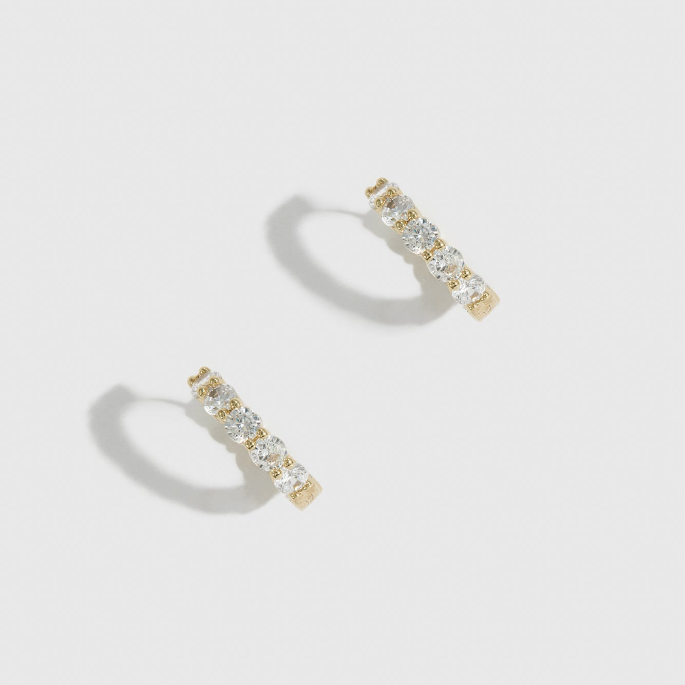 14k gold plated sterling silver 925 inside-out pavé huggies with cubic zirconia, shown on a plain background.