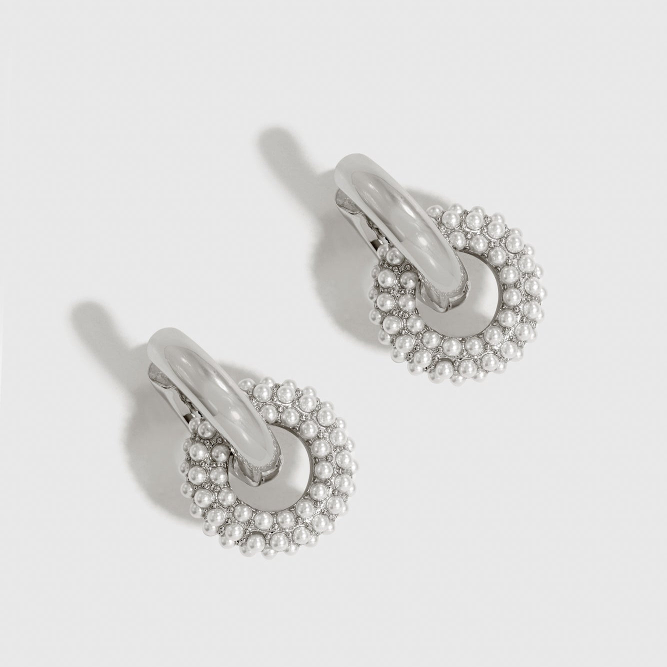 Silver plated pearl pavé convertible huggies with pearls, shown on a plain background.