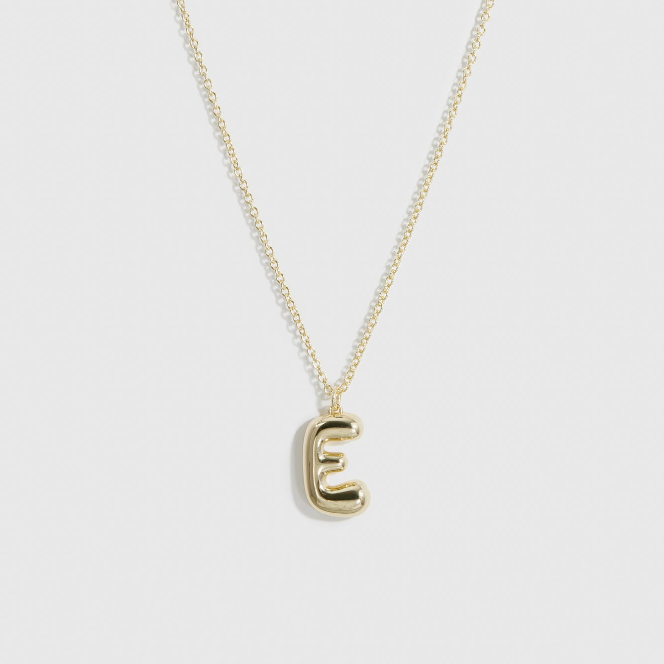 14k gold plated sterling silver 925 liquid bubble letter pendant necklace, shown on a plain background.