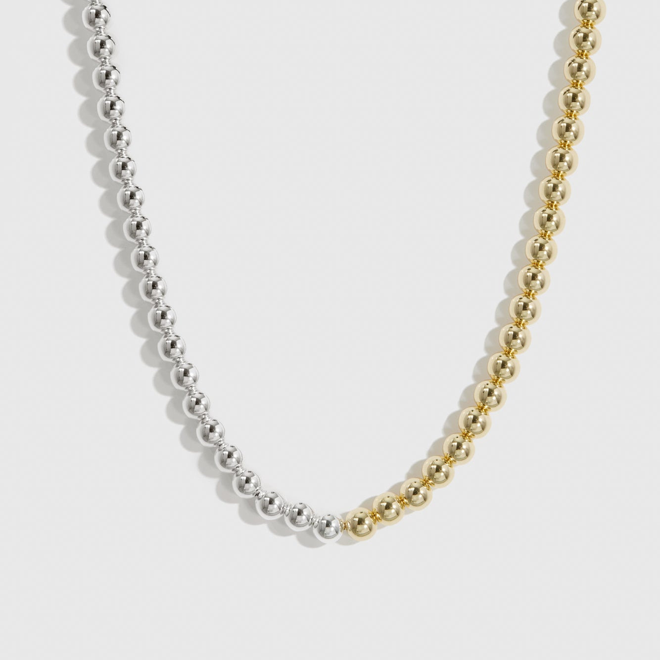 Mixed metal beaded necklace, shown on a plain background.