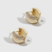 14k gold plated Vega huggie earrings with a pearl, shown on a plain background.