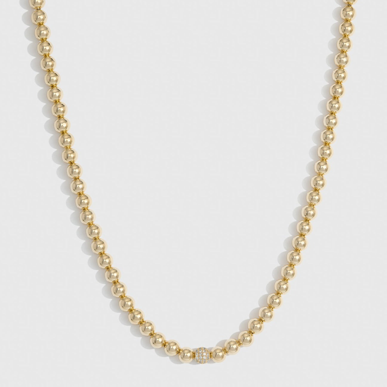 14k gold plated refined necklace with cubic zirconia and a pearl, shown on a plain background.