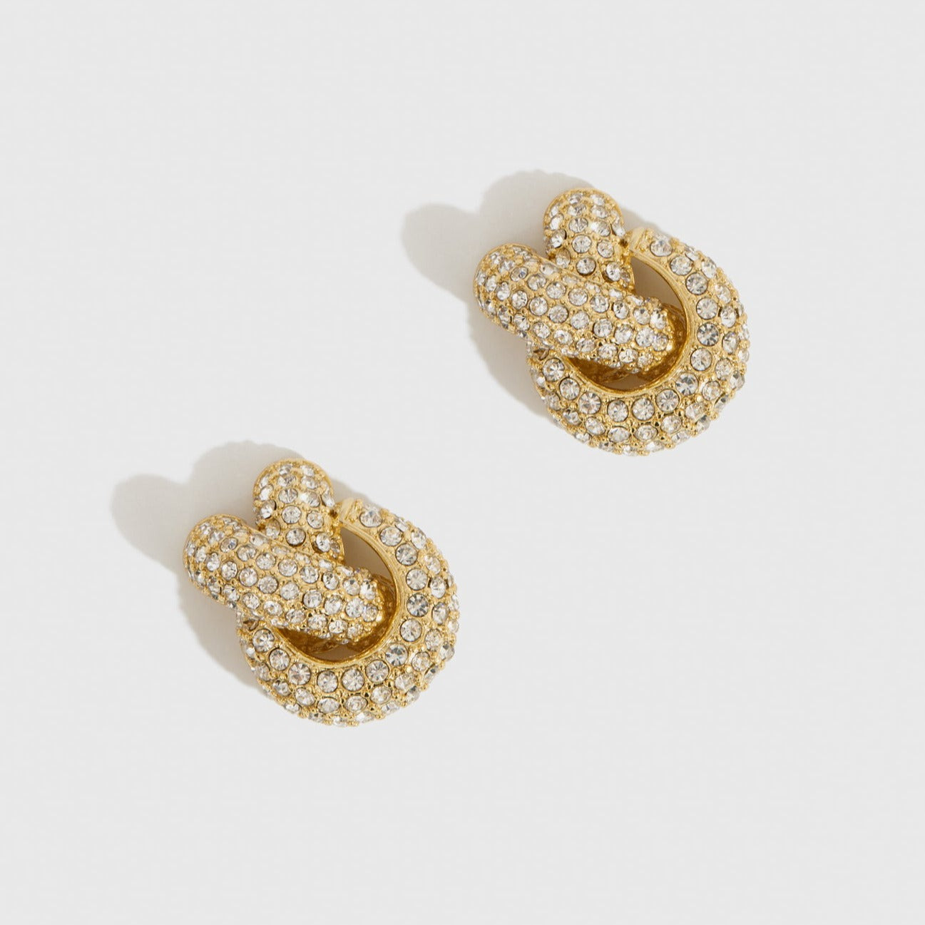 14k gold plated knot earrings with cubic zirconia, shown on a plain background.
