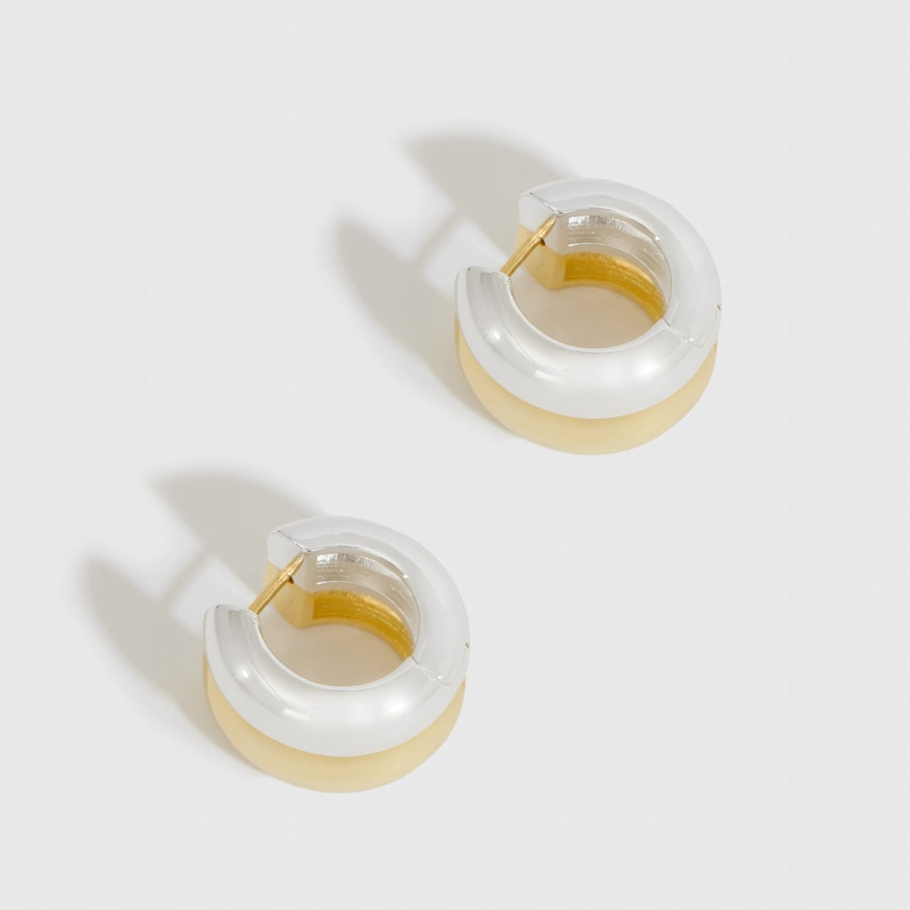 Mixed metal luminous earrings, shown on a plain background.