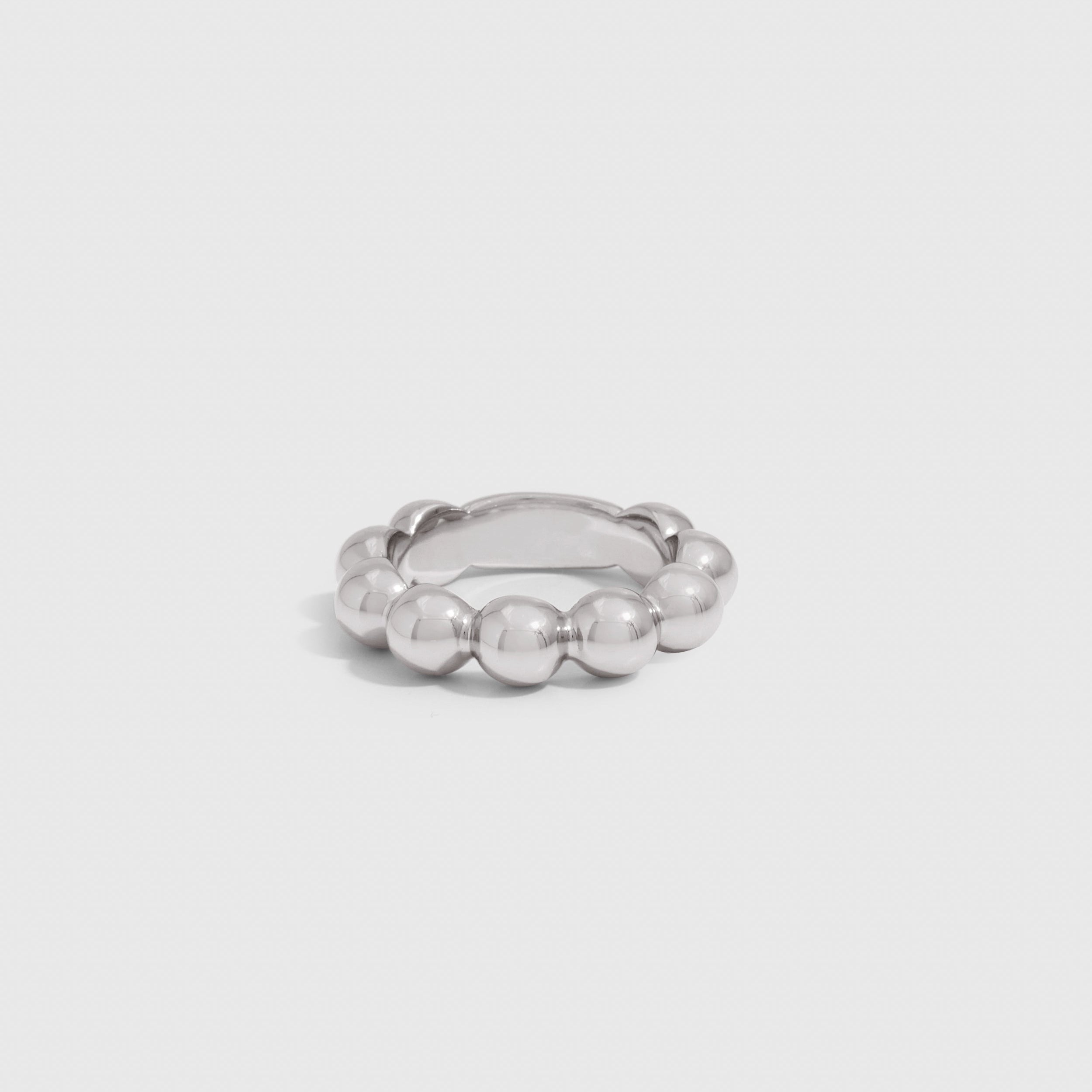 Silver beaded ring showing a row of small beads circling the band, shown on a plain background.