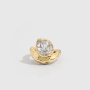 14k gold plated statement ring with a teardrop-cut cubic zirconia on a wavy organic band, shown on a plain background.