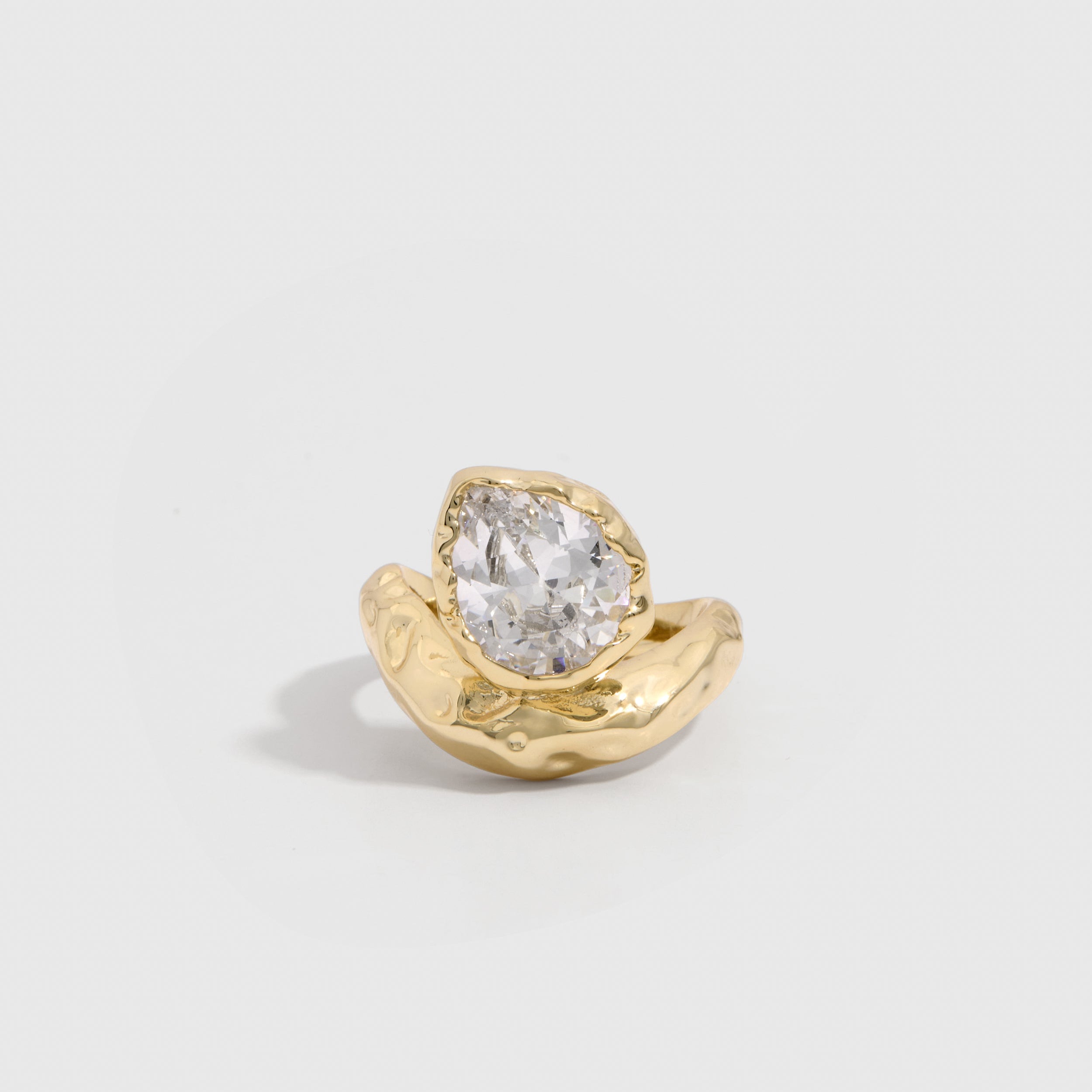 14k gold plated statement ring with a teardrop-cut cubic zirconia on a wavy organic band, shown on a plain background.