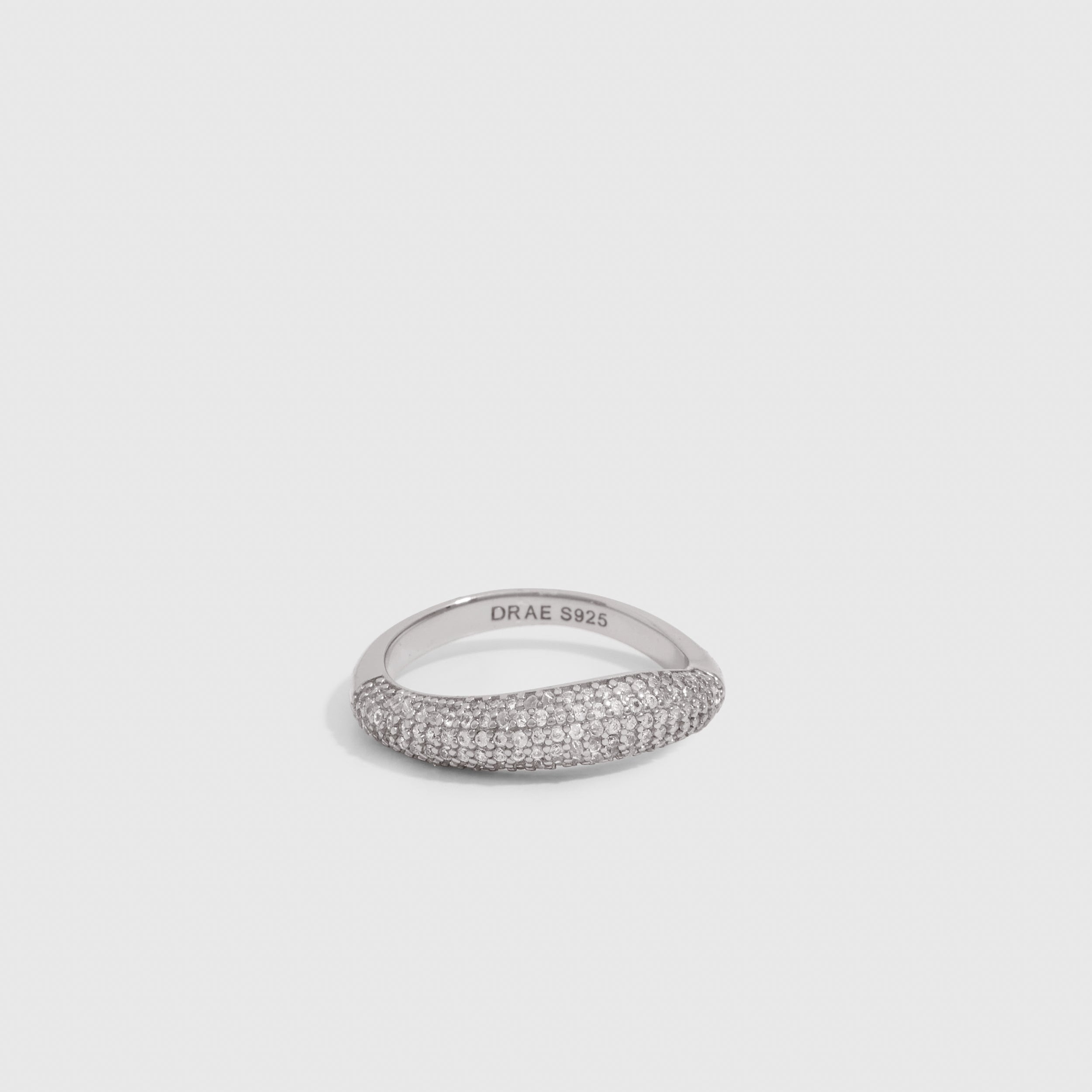 Silver wavy pavé ring with round-cut cubic zirconia set edge to edge, shown on a plain background.