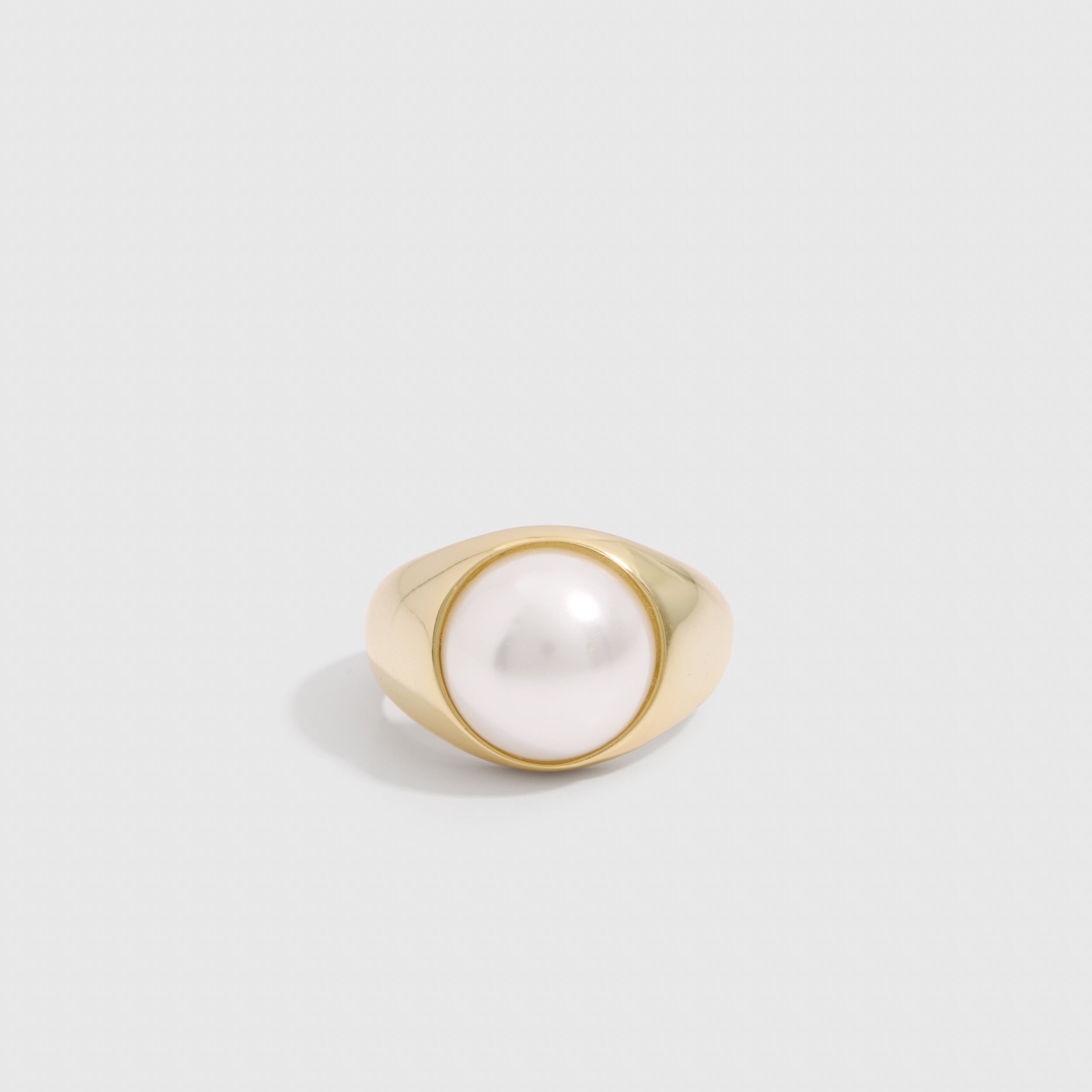 14k gold plated dome ring with a half freshwater pearl set proud of the band, shown on a plain background.