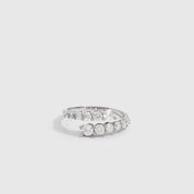 Silver graduated cubic zirconia wrap ring with four stone sizes tapering across the band, shown on a plain background.