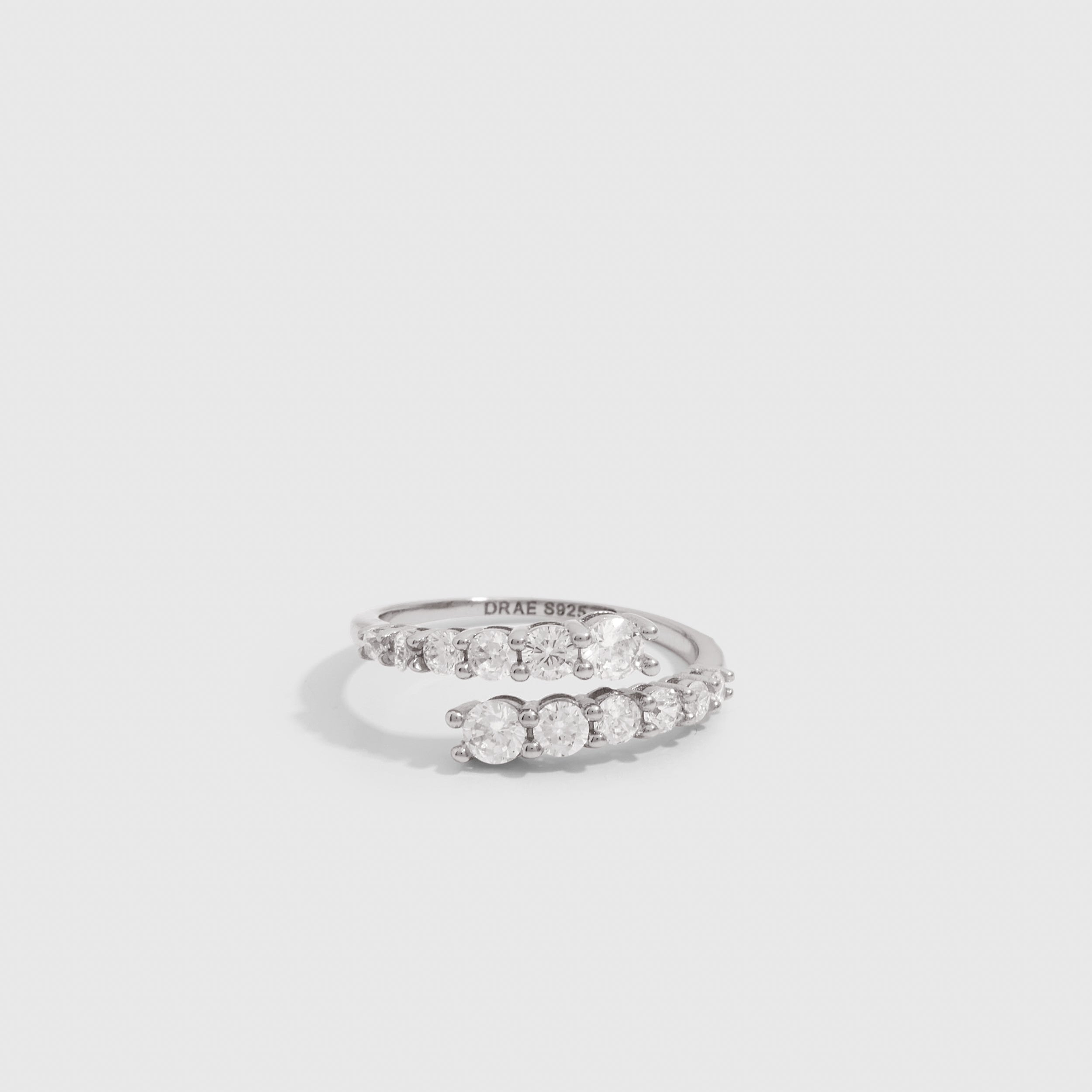 Silver graduated cubic zirconia wrap ring with four stone sizes tapering across the band, shown on a plain background.