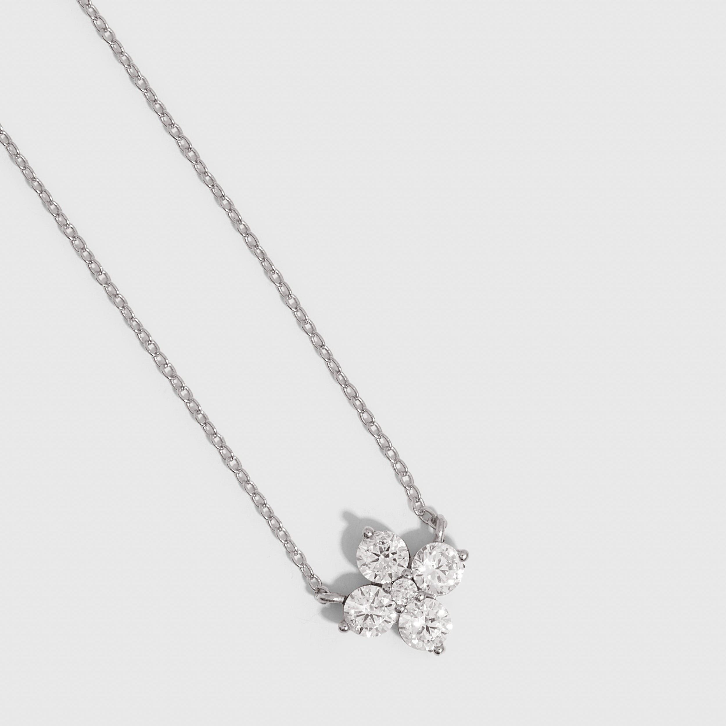 Silver clover motif pendant necklace with cubic zirconia detailing on a cable chain, shown on a plain background.