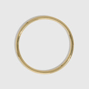 14k gold plated delicate stackable bangle bracelet shown on a plain background.