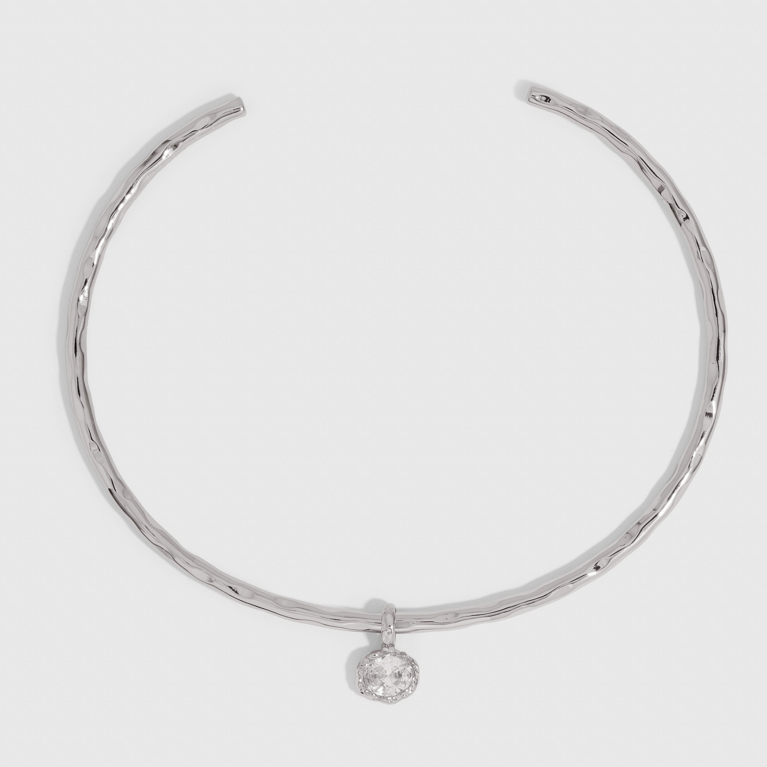 Silver hammered neck cuff necklace with a detachable cubic zirconia charm, shown on a plain background.