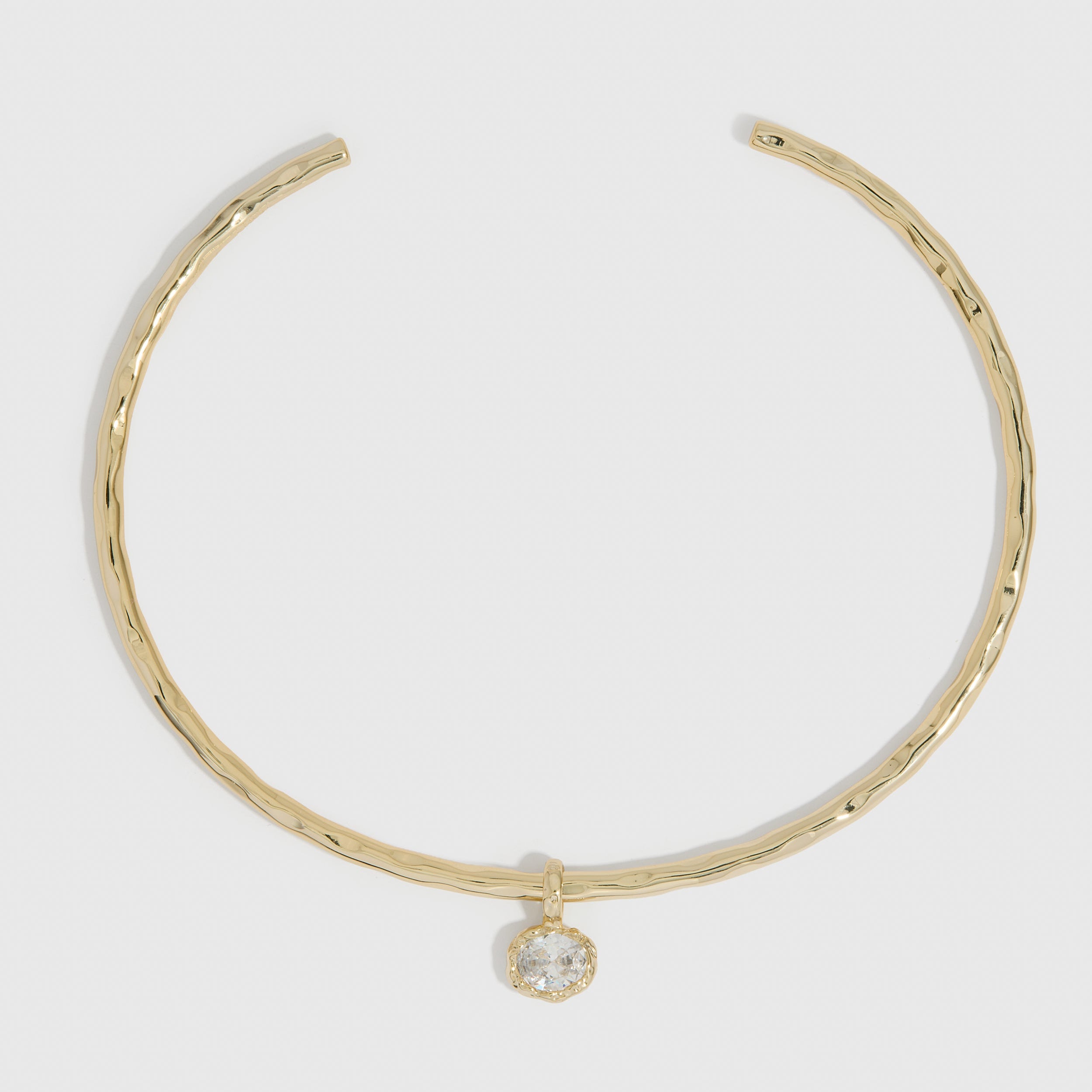 14k gold plated hammered neck cuff necklace with a detachable cubic zirconia charm, shown on a plain background.