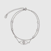 Silver anklet with an evil eye pendant and cubic zirconia pavé detailing, shown on a plain background.