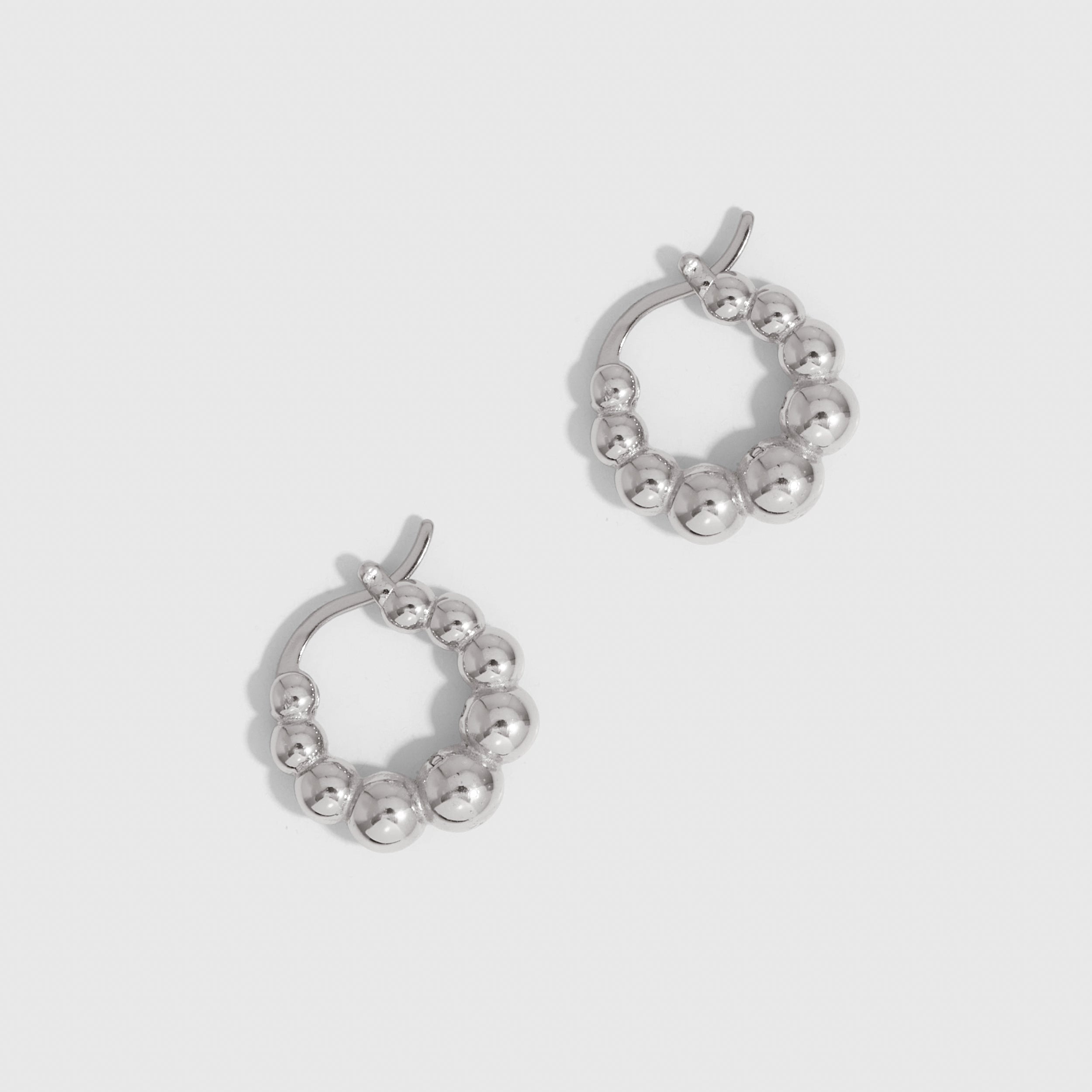Silver beaded hoop earrings showing small beads strung along the hoop, shown on a plain background.