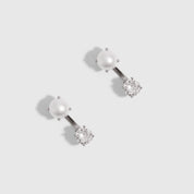 Silver barbell earrings combining a freshwater pearl and a round-cut cubic zirconia, shown on a plain background.