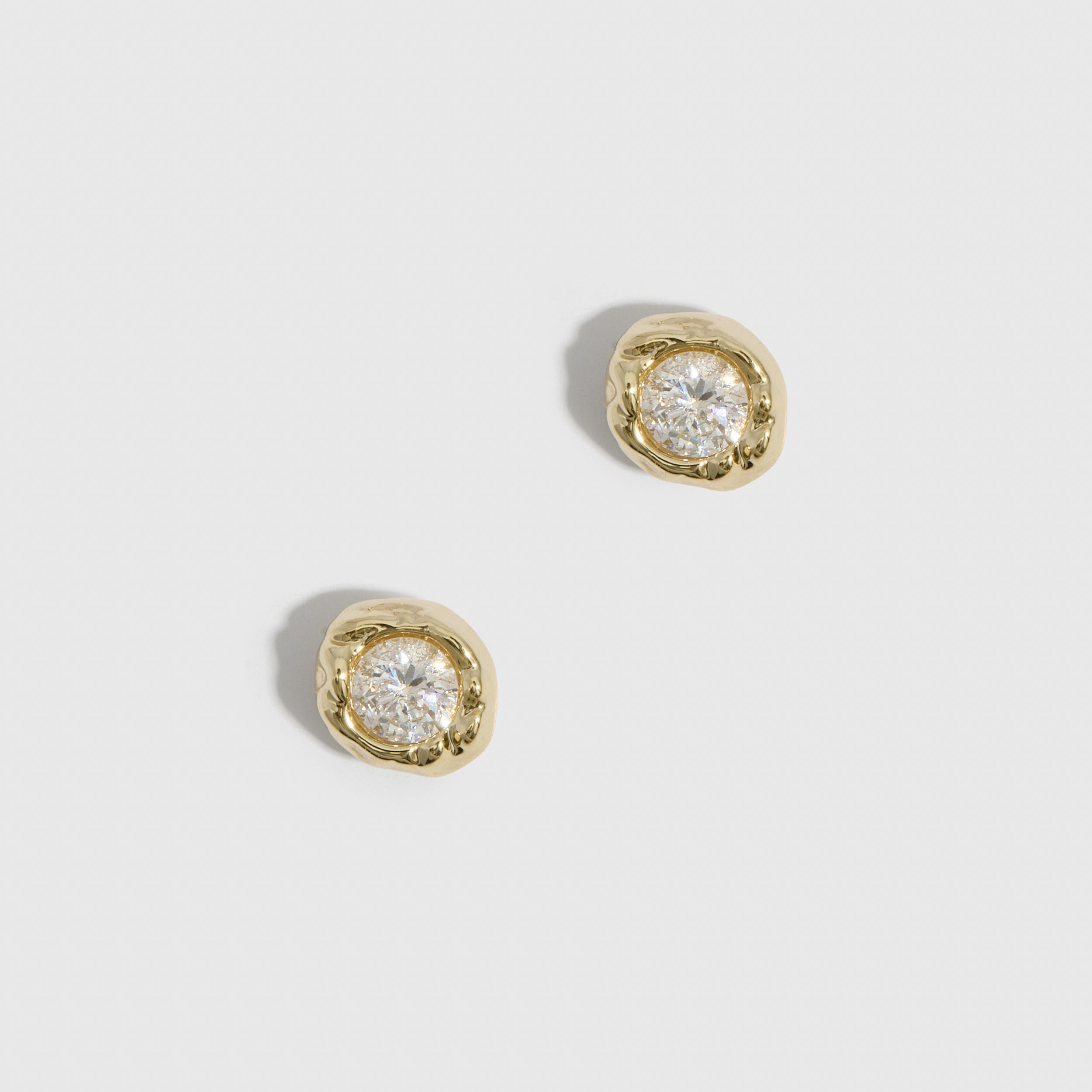 14k gold plated organic stud earrings with a round-cut cubic zirconia in a nugget bezel, shown on a plain background.