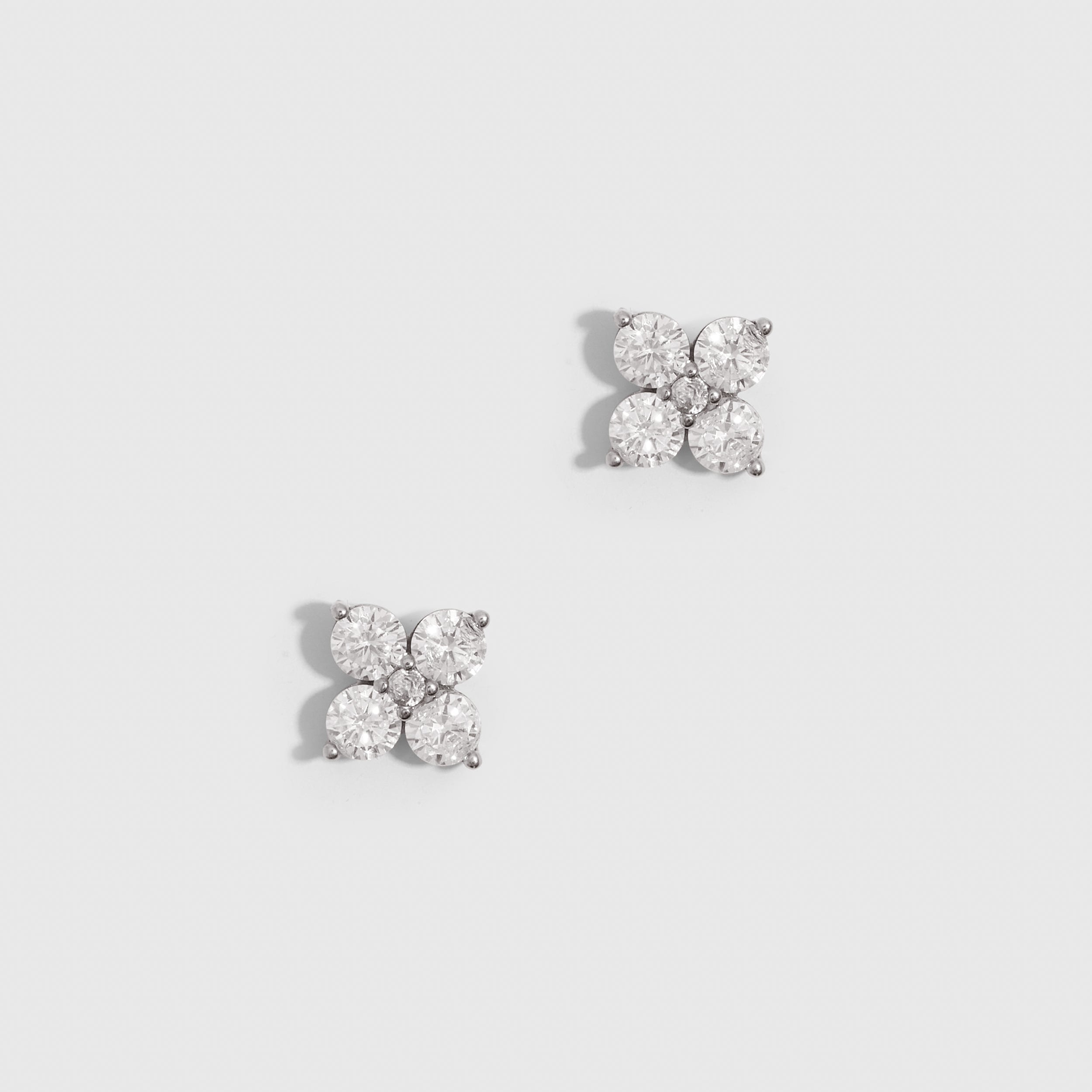 Silver clover motif stud earrings with cubic zirconia detailing, shown on a plain background.