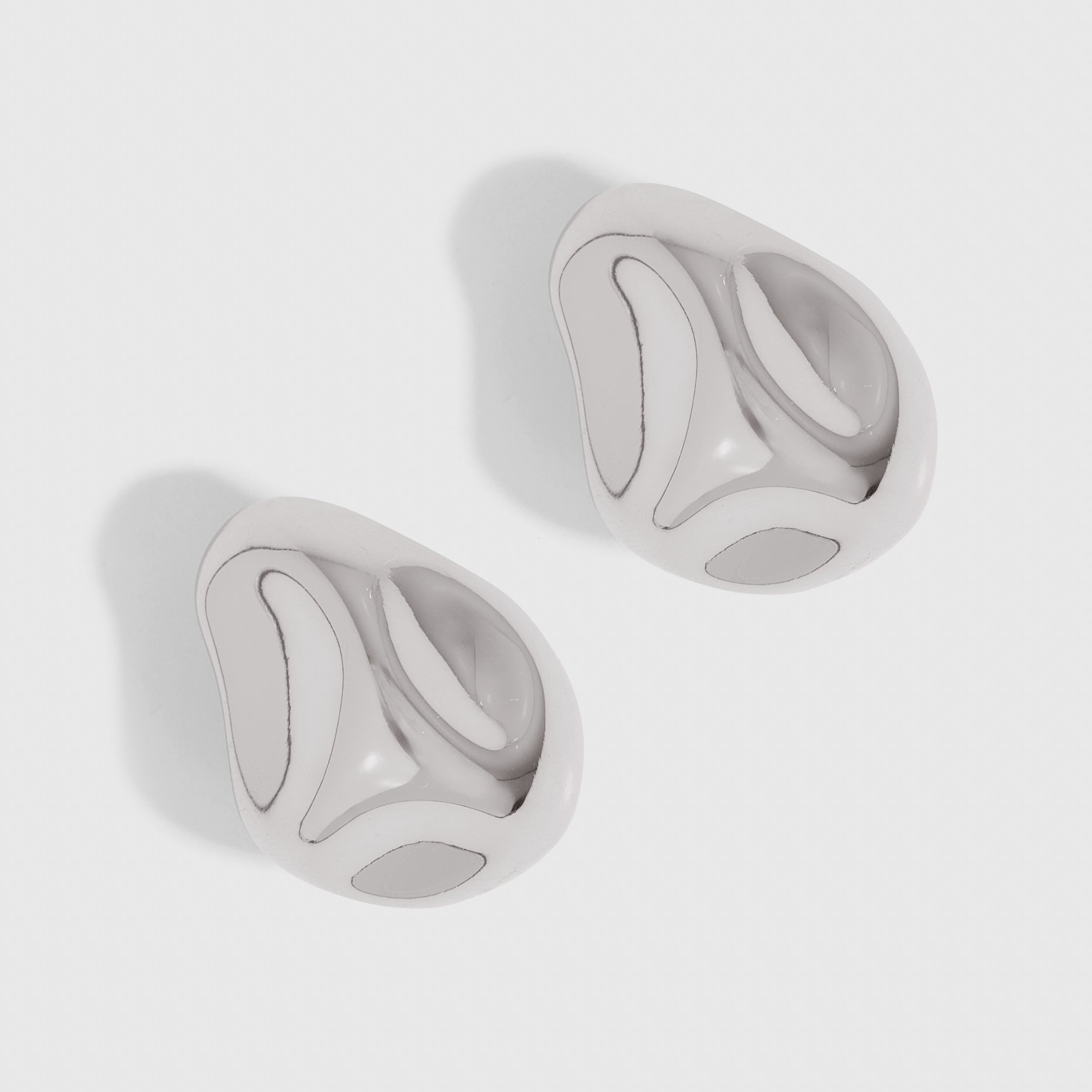 Silver geometric stone earrings with bold architectural lines, shown on a plain background.