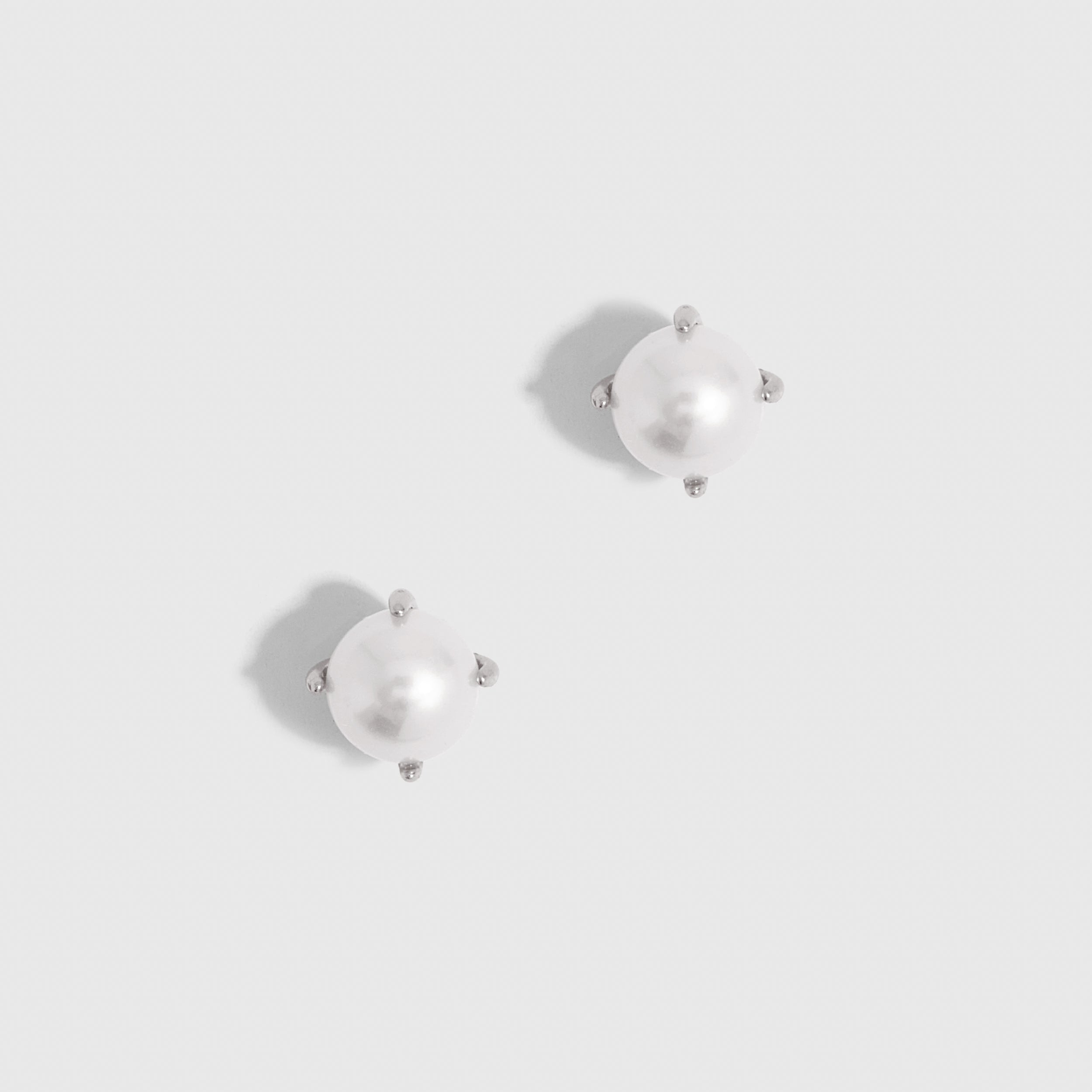 Silver stud earrings with a genuine round freshwater pearl, shown on a plain background.