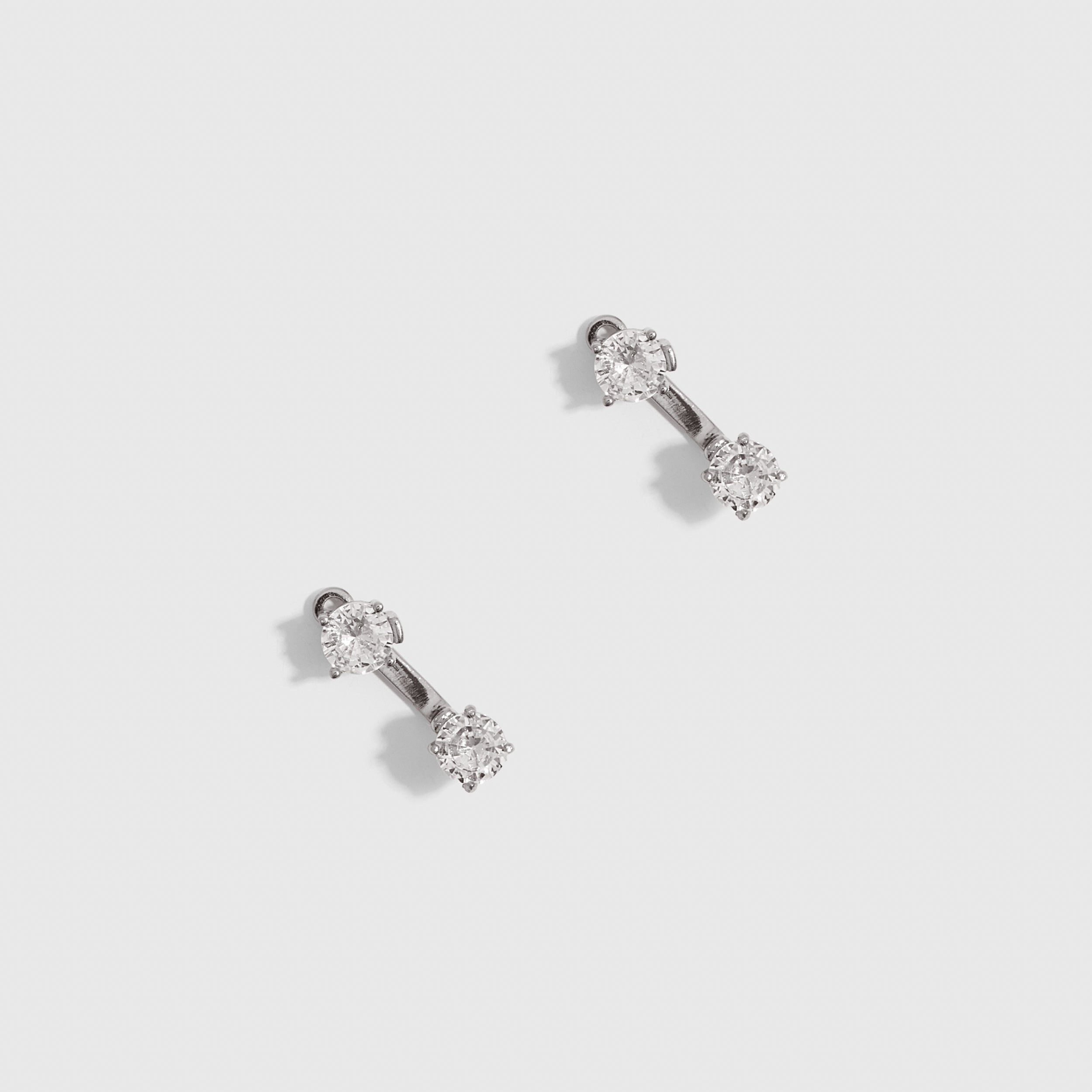 Silver round-cut cubic zirconia barbell stud earrings, shown on a plain background.