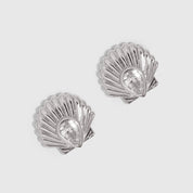 Silver seashell stud earrings with a teardrop-cut cubic zirconia, shown on a plain background.
