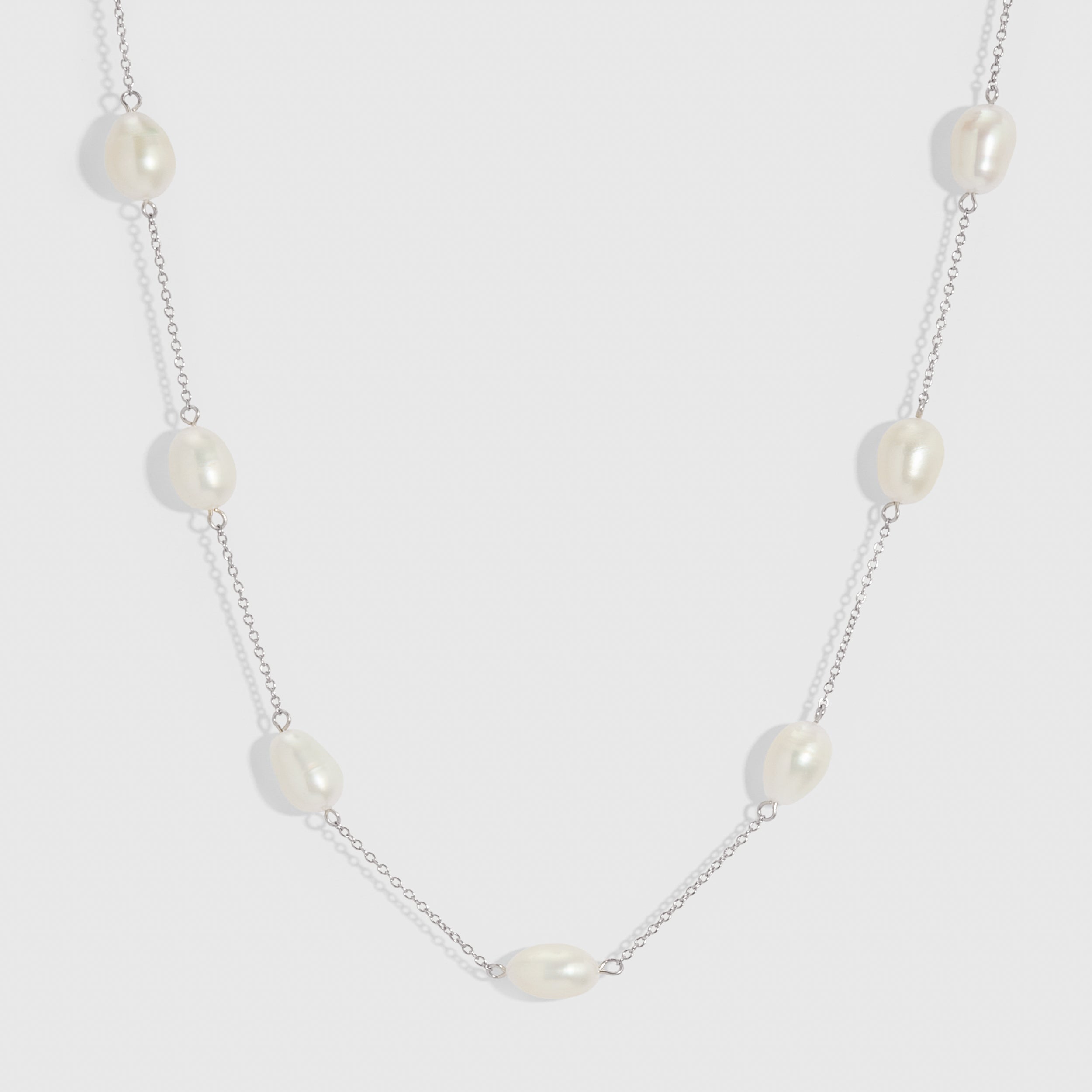 Silver necklace with genuine baroque pearls of varied irregular shapes, shown on a plain background.