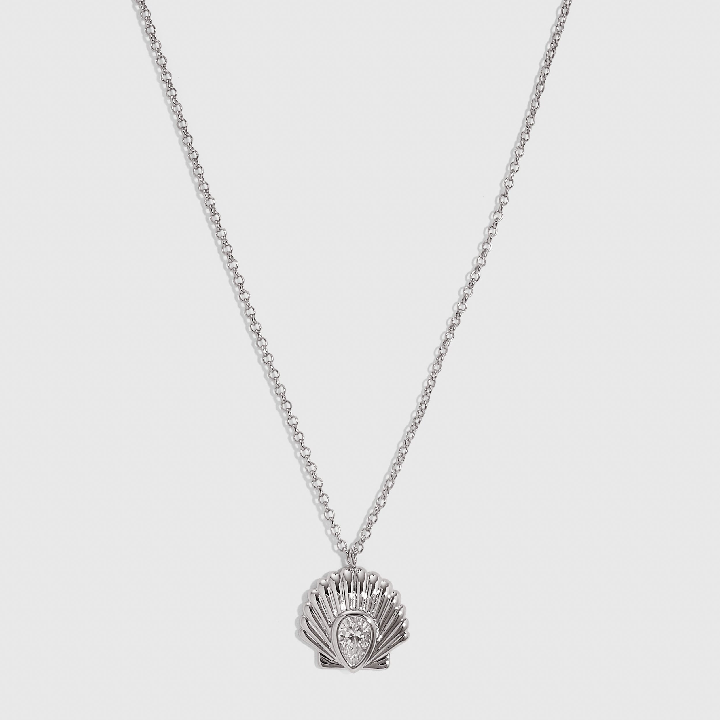 Silver seashell pendant necklace with a teardrop-cut cubic zirconia, shown on a plain background.