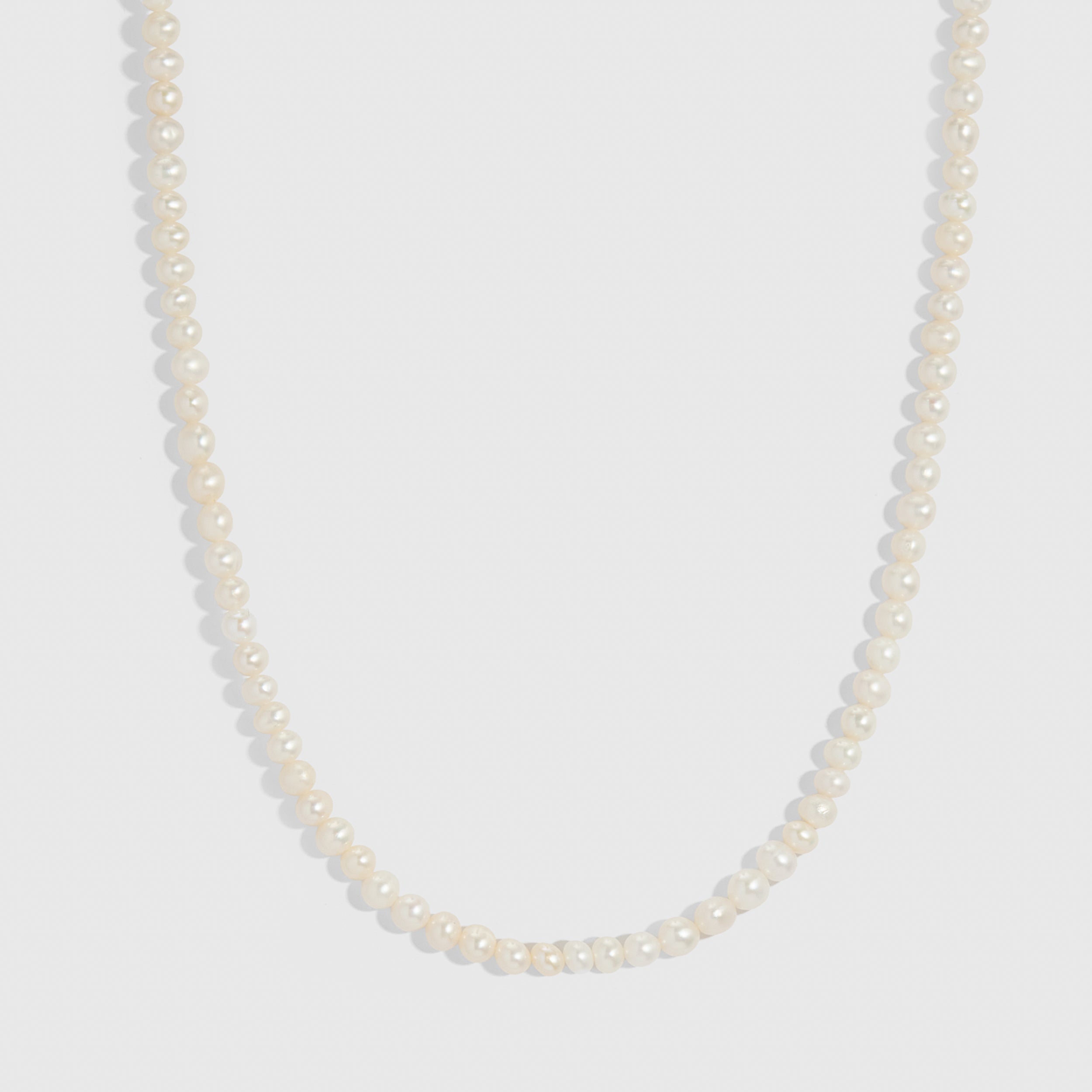 14k gold detailed necklace with genuine round freshwater pearls on a fabric cord, shown on a plain background.