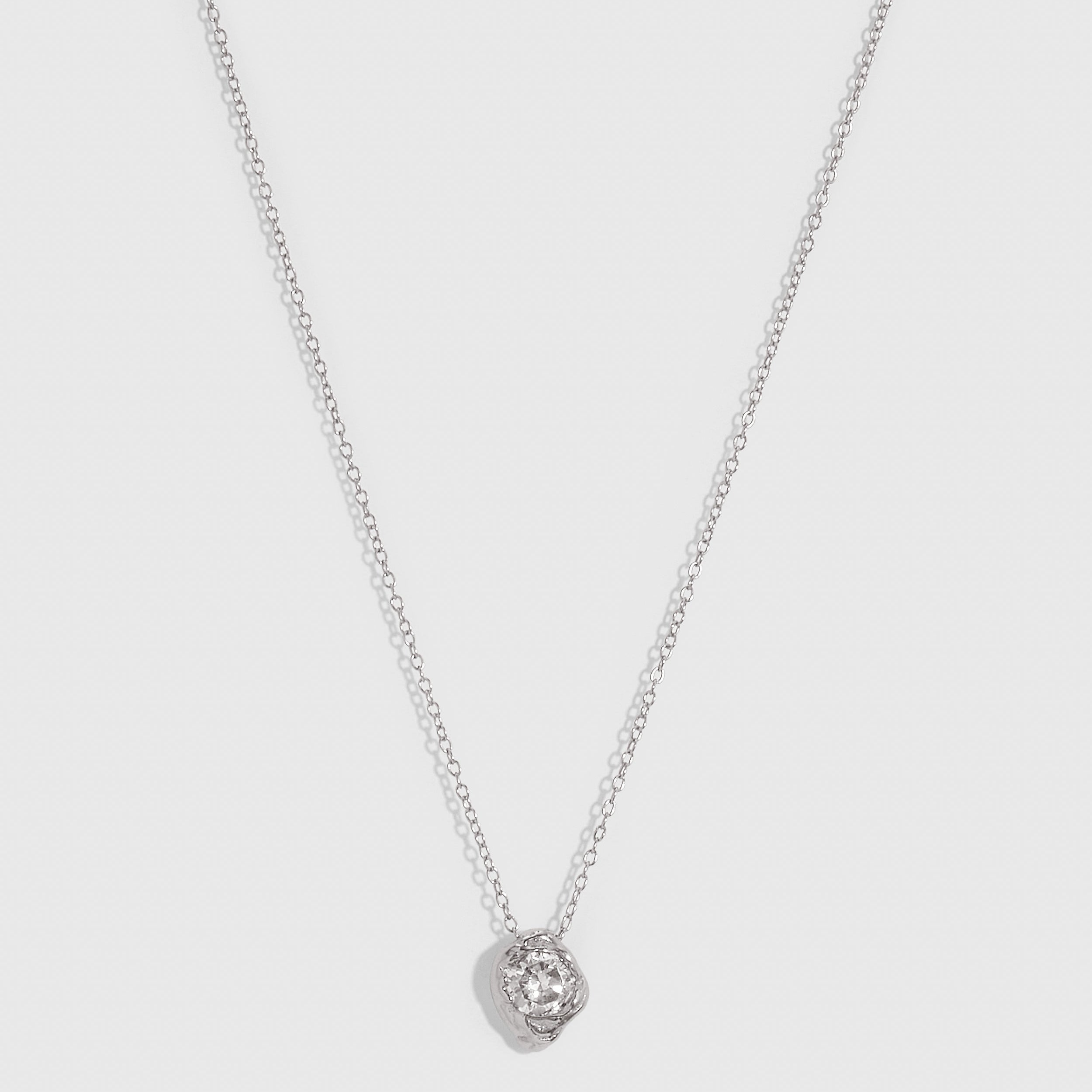 Silver solitaire nugget pendant necklace with bezel-set cubic zirconia, shown on a plain background.