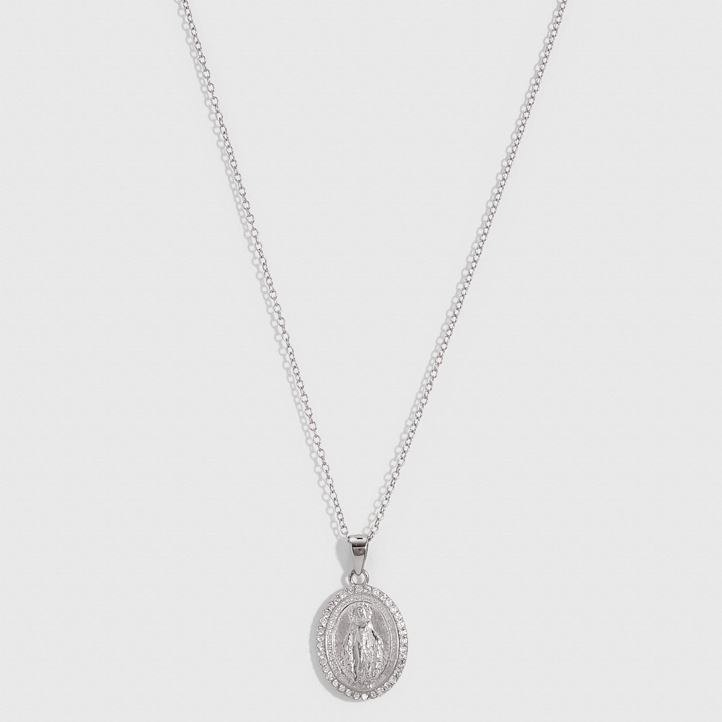 Silver Virgin Mary pendant necklace with pavé cubic zirconia edging on a fine cable chain, shown on a plain background.