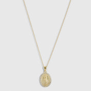 14k gold plated Virgin Mary pendant necklace with pavé cubic zirconia edging on a fine cable chain, shown on a plain background.